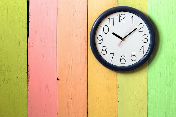 El reloj cuelga de una valla multicolor