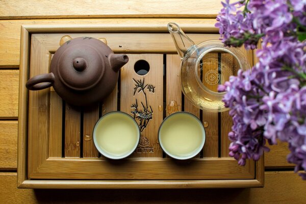 Thé d une théière en argile entourée de lilas