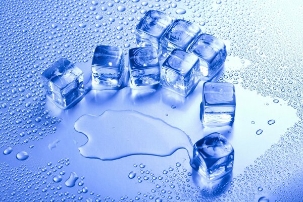 Ice cubes on a blue background with drops