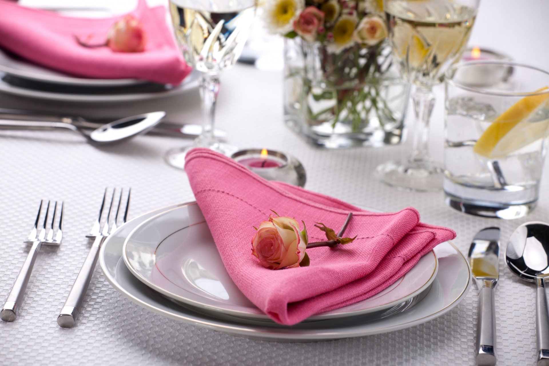 servir table rose fleur serviette assiettes couverts couteaux fourchettes bougie verres verres à vin