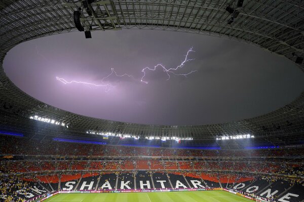 Fußballspiel am offenen Himmel und Gewitter