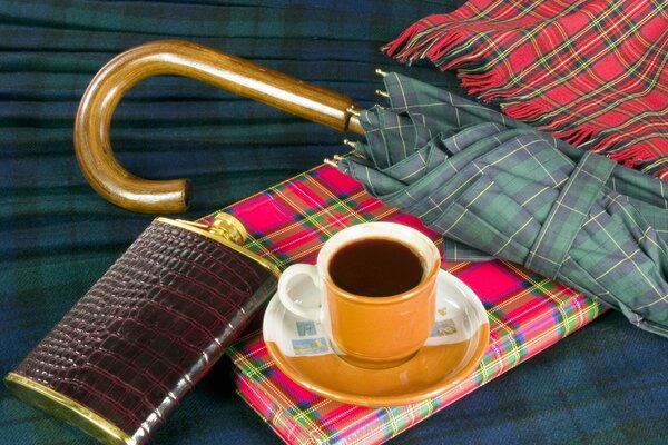 Composition of a flask, an umbrella, a notebook and a plaid plaid