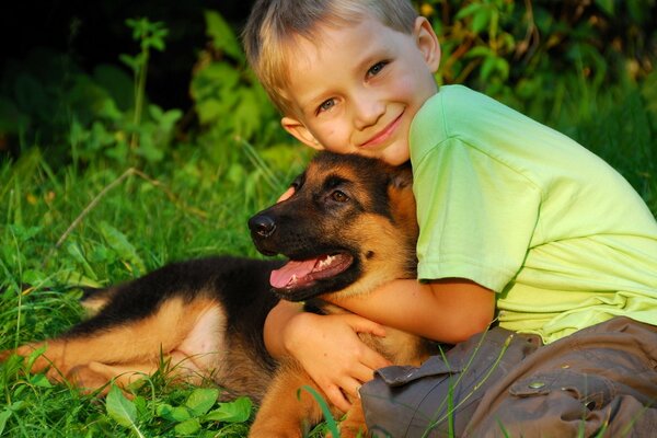 Boy and puppy are friends, hugging each other