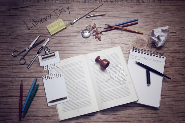 A calendar with a book and stationery with a notebook on the background