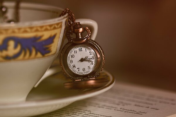 A mug with a pocket watch on the table