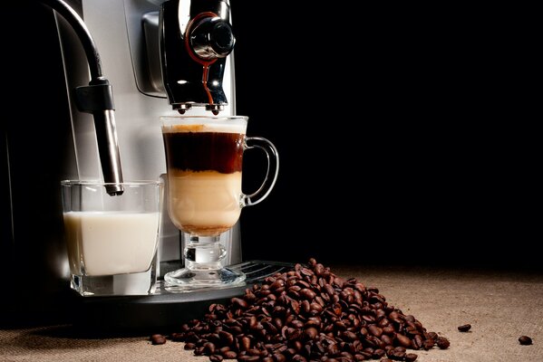 Coffee and milk in a coffee machine on a black background