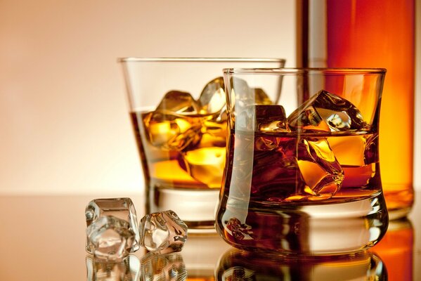 Immagine di bicchieri di ghiaccio e whisky in piedi sul tavolo