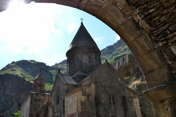 Picture of an old church against the background of wooded mountains