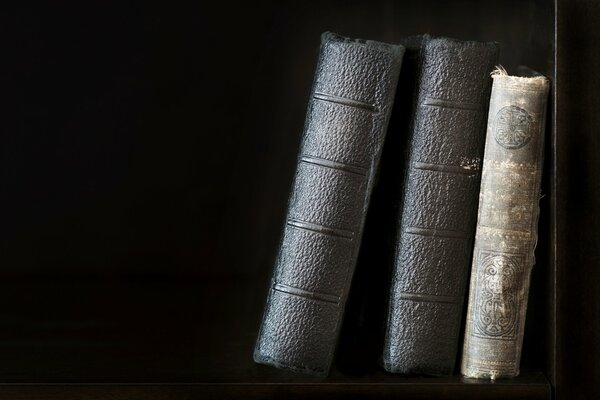 Immagine di vecchi libri in piedi su uno scaffale su uno sfondo scuro