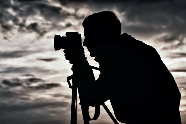 Silhouette of a man with a camera at night