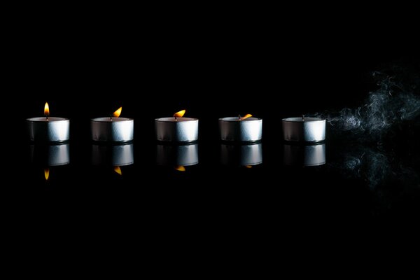 Reflection of lighted candles on a black table