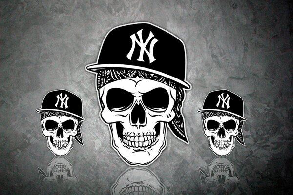 Tres calaveras con gorras sobre fondo gris