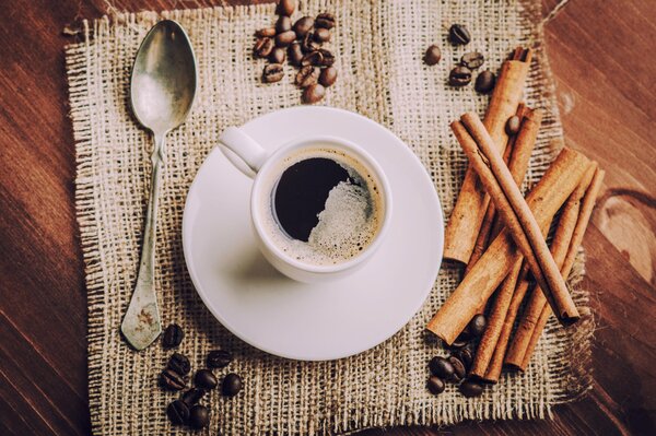 Cuchara de plata junto a una taza de café con vainilla