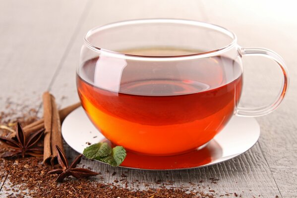 A cup of tea on a saucer with cinnamon