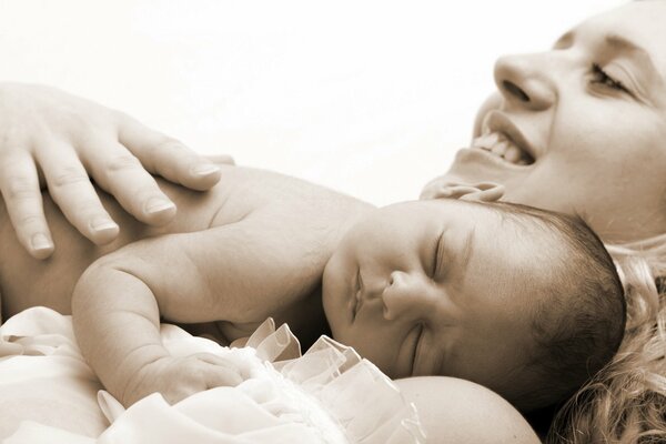 A woman hugs a sleeping baby to her