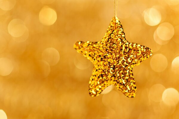 Giocattolo di Natale a forma di stella scintillante d oro