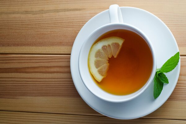 Tè al limone e menta in una tazza bianca