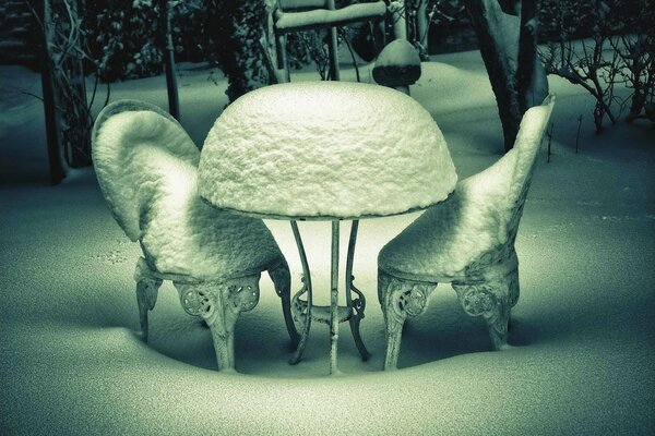 Pokryte śniegiem krzesła i stół w mroźny dzień Na Zewnątrz