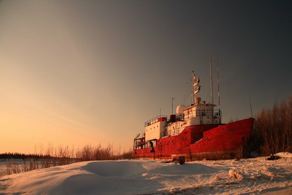 An abandoned ship in the snow in winter