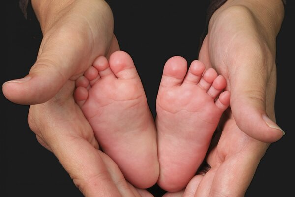 Immagine delle mani della madre e delle gambe del bambino