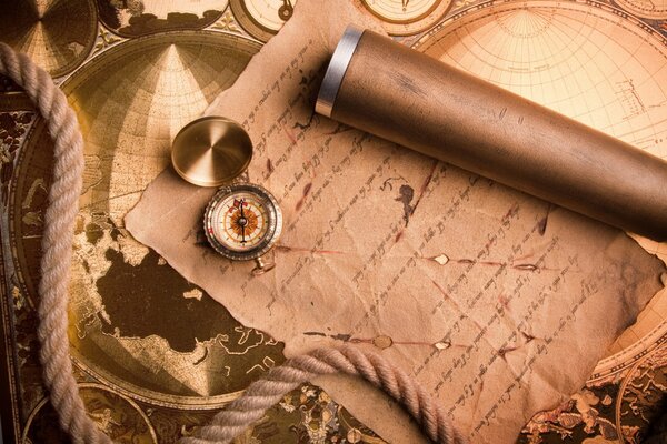 A compass lying on a paper manuscript against the background of historical maps