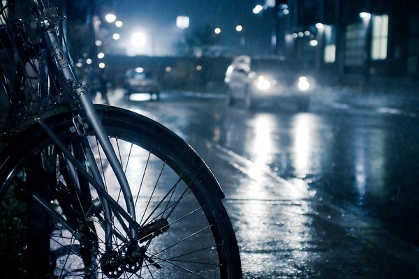 Fahrrad in der Nachtstraße bei regnerischem Wetter