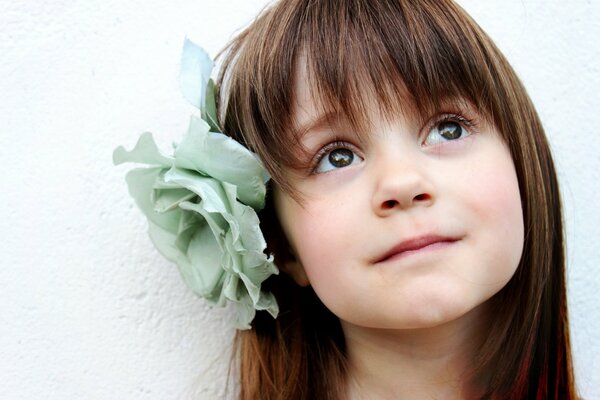 Bel bambino con un fiore tra i capelli