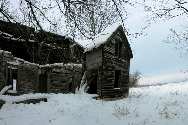 Заброшенный дом на окраине зимним днём