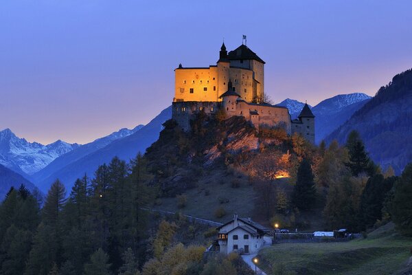 Title château en Suisse sur une colline le soir