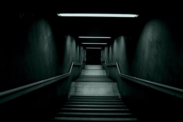 Dark with stairs and railings and a light