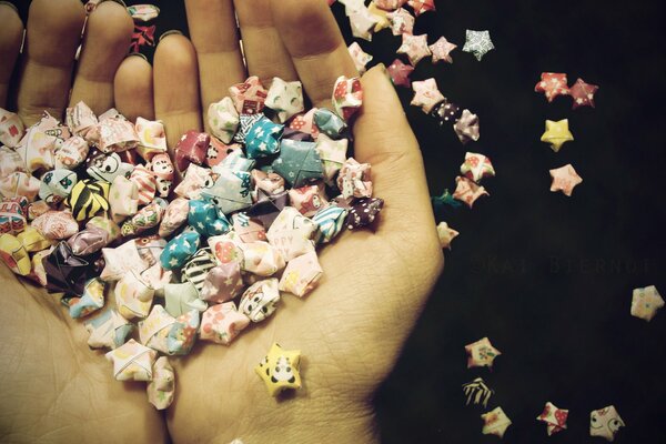 Envoltorios de dulces, corazones y estrellas se encuentran en las Palmas de las manos