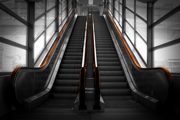 Escalator avec garde-corps dans une pièce vitrée