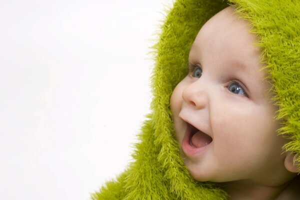 Il bambino con il cappuccio verde sorride