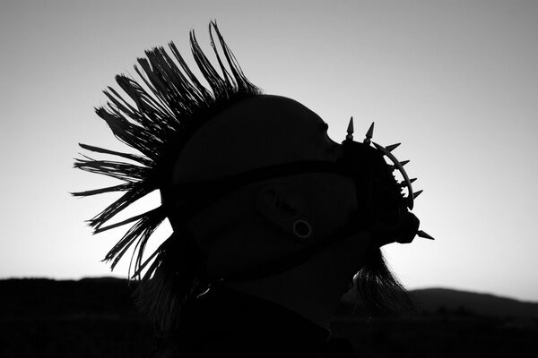 Silhouette of a punk in a spiked muzzle