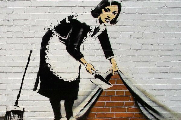 Graffiti femme de ménage sur un mur de briques