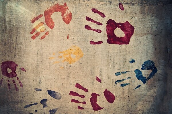 Empreintes de mains sur le mur de béton multicolore