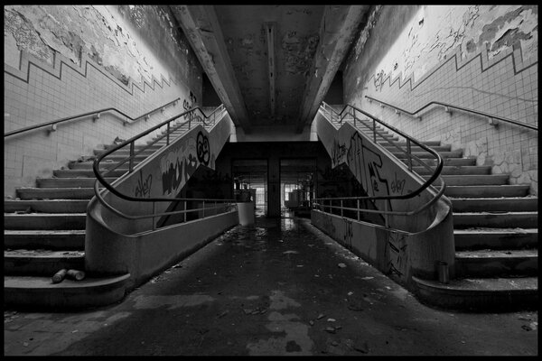 Stairs to the entrance of an old building with graffiti