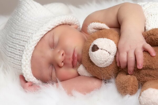 Bebé durmiendo en un gorro de oso de peluche