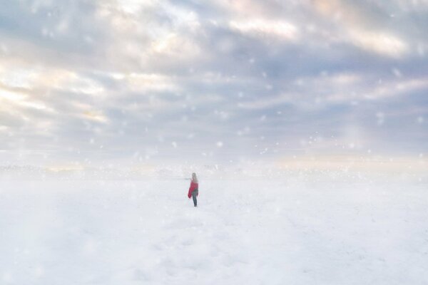 Chica solitaria en un campo cubierto de nieve