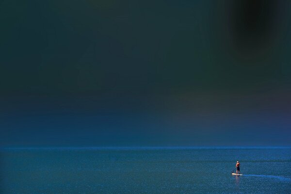 Homme sur un tableau noir dans la mer seul