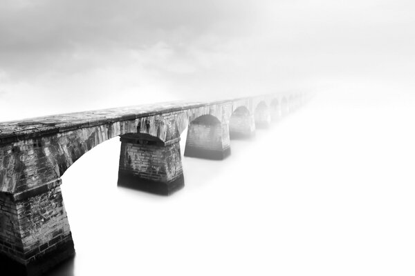 Puente en la niebla en el fondo