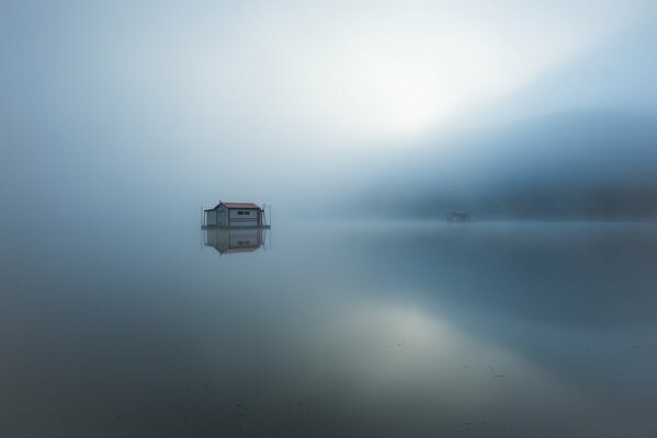 Am See ist Nebel und nur in der Ferne kann man ein kleines Haus auf dem Pilaw sehen