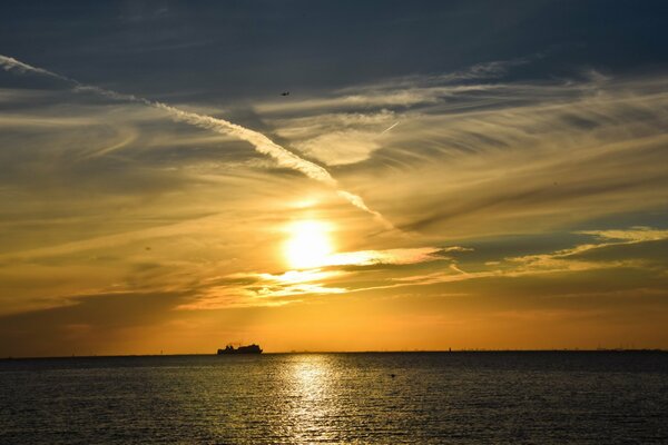 Puesta de sol sobre el mar, un barco solitario