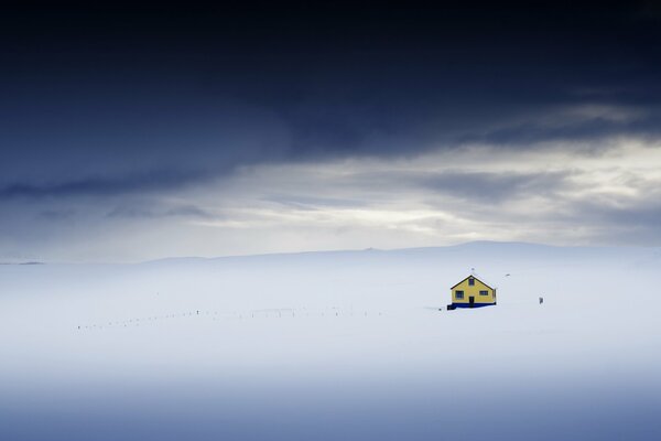 Maison solitaire dans un champ enneigé