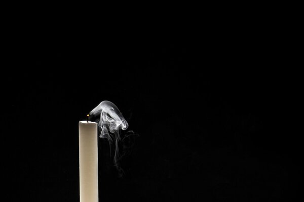 A extinguished candle on a black background