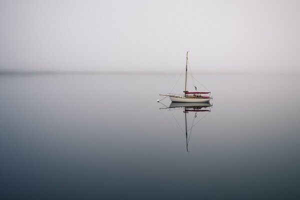 Im schönen Meer schwimmt ein Boot im Nebel