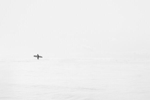 A man with a board in the clear sea