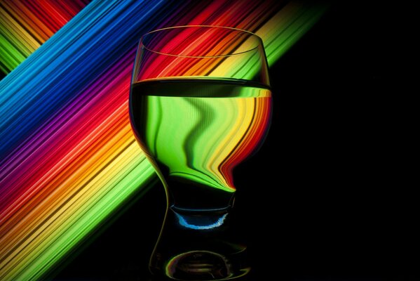 Un vaso de agua sobre un fondo multicolor