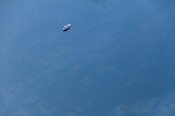 Enorme mar azul con un barco solitario