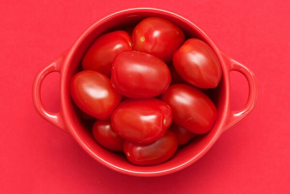 Taza roja con asas y tomate